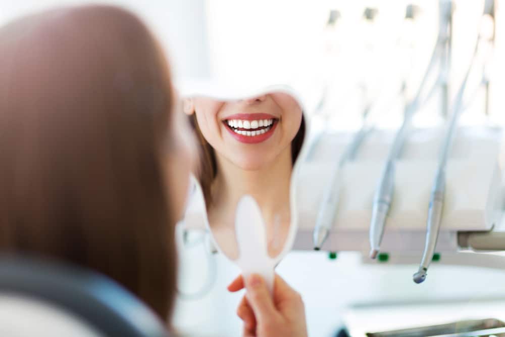 woman looking at smile after gum treatment in winnipeg
